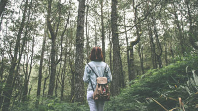 image of woman walking through forest